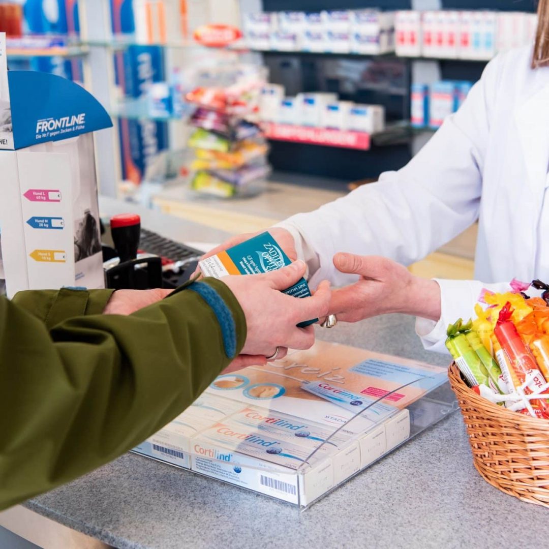 Kunde kauft Medikament in der Apotheke.
