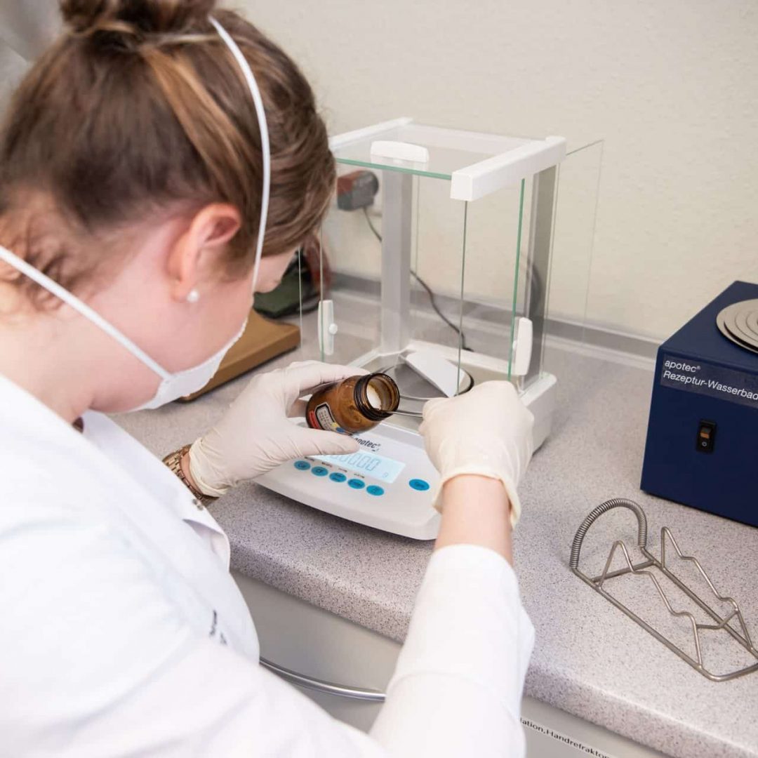 Laborant wiegt Substanz in Laborwaage ab.